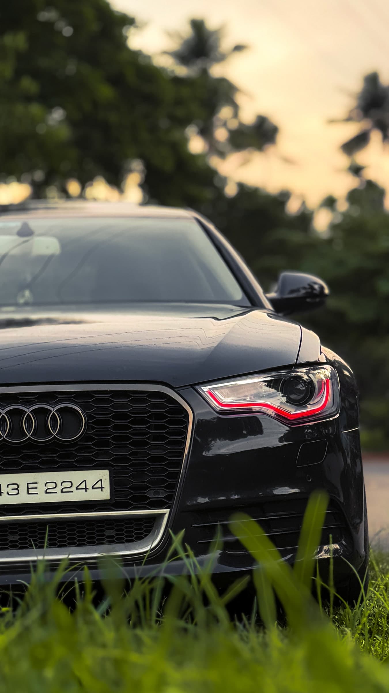 Close front detail of a black Audi with a red headlight accent