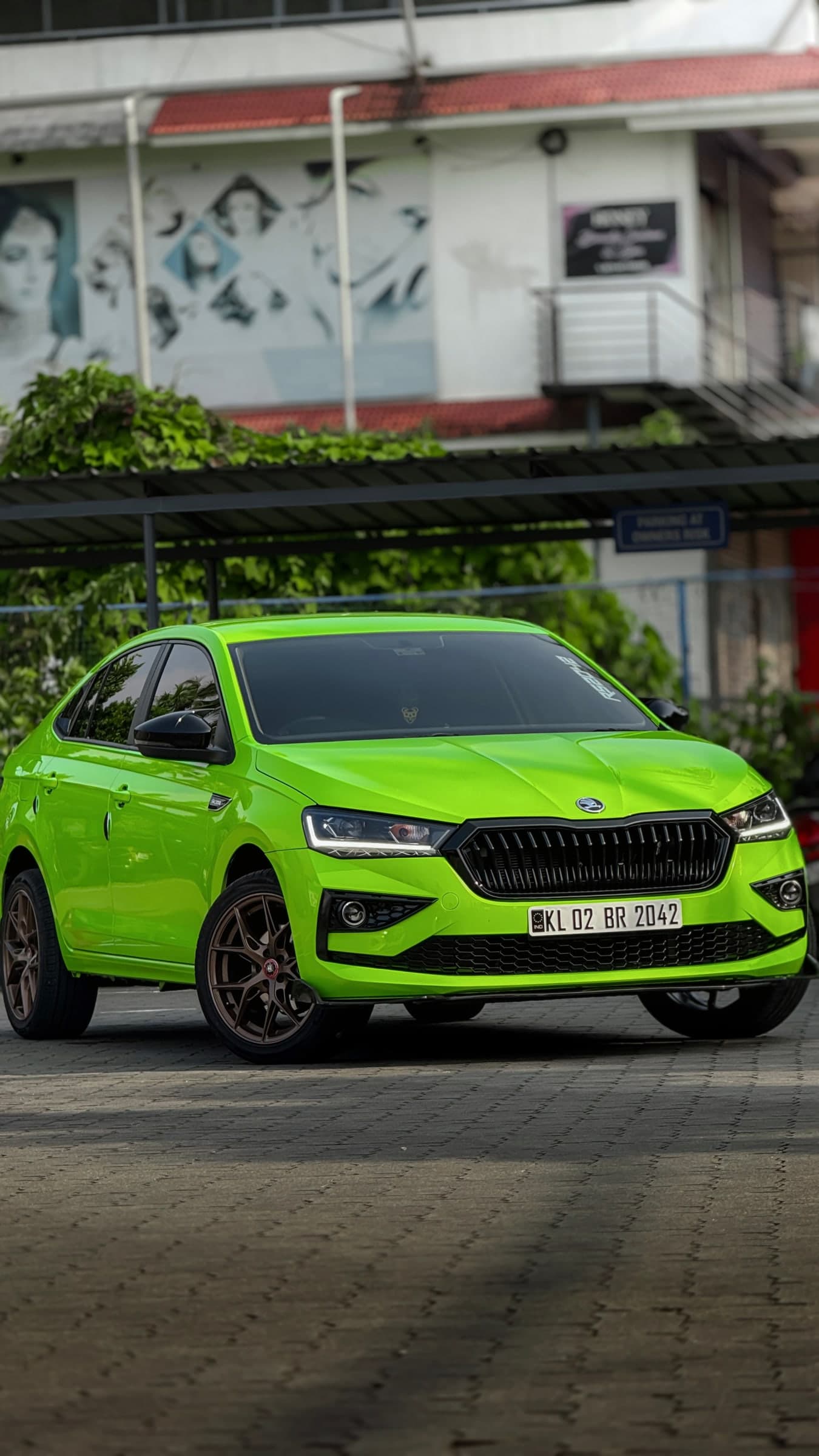 Bright green modified sedan photographed in three-quarter profile